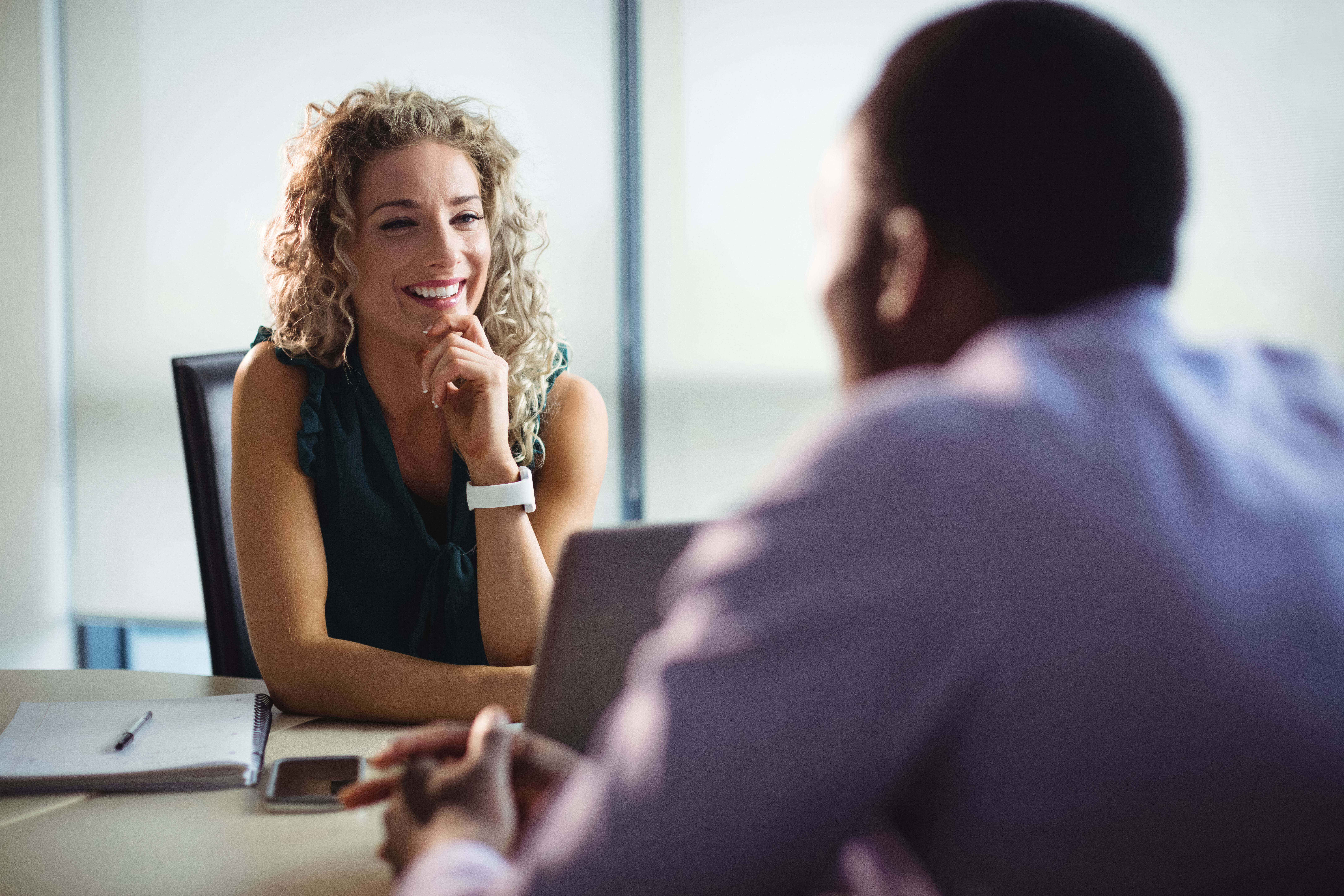 Femme souriante en rendez-vous avec un homme dans un bureau