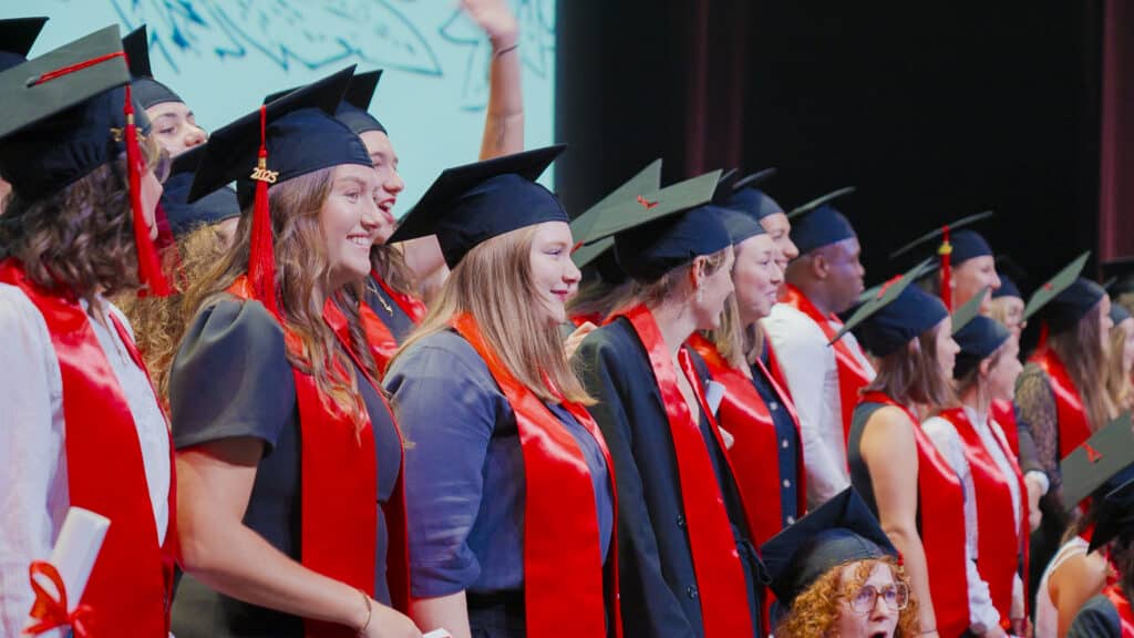 Diplômés en toge et étole rouge lors de la cérémonie de remise des diplômes du Cnam