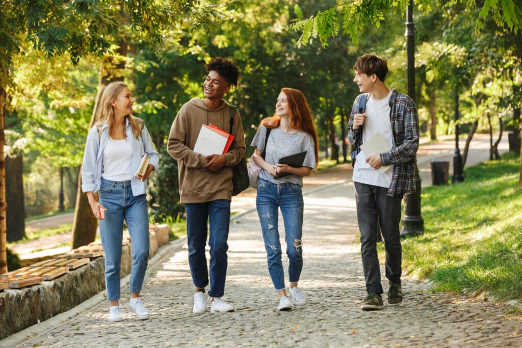 Étudiants marchent ensemble sur une allée arborée d'un campus