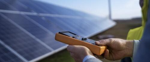 Technicien mesure un panneau solaire avec un appareil de contrôle