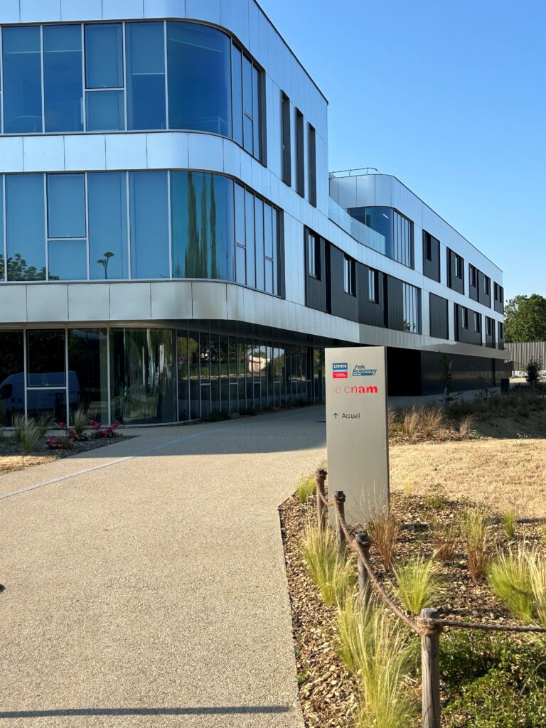 Bâtiment vitré du campus du Mans et son allée d'entrée