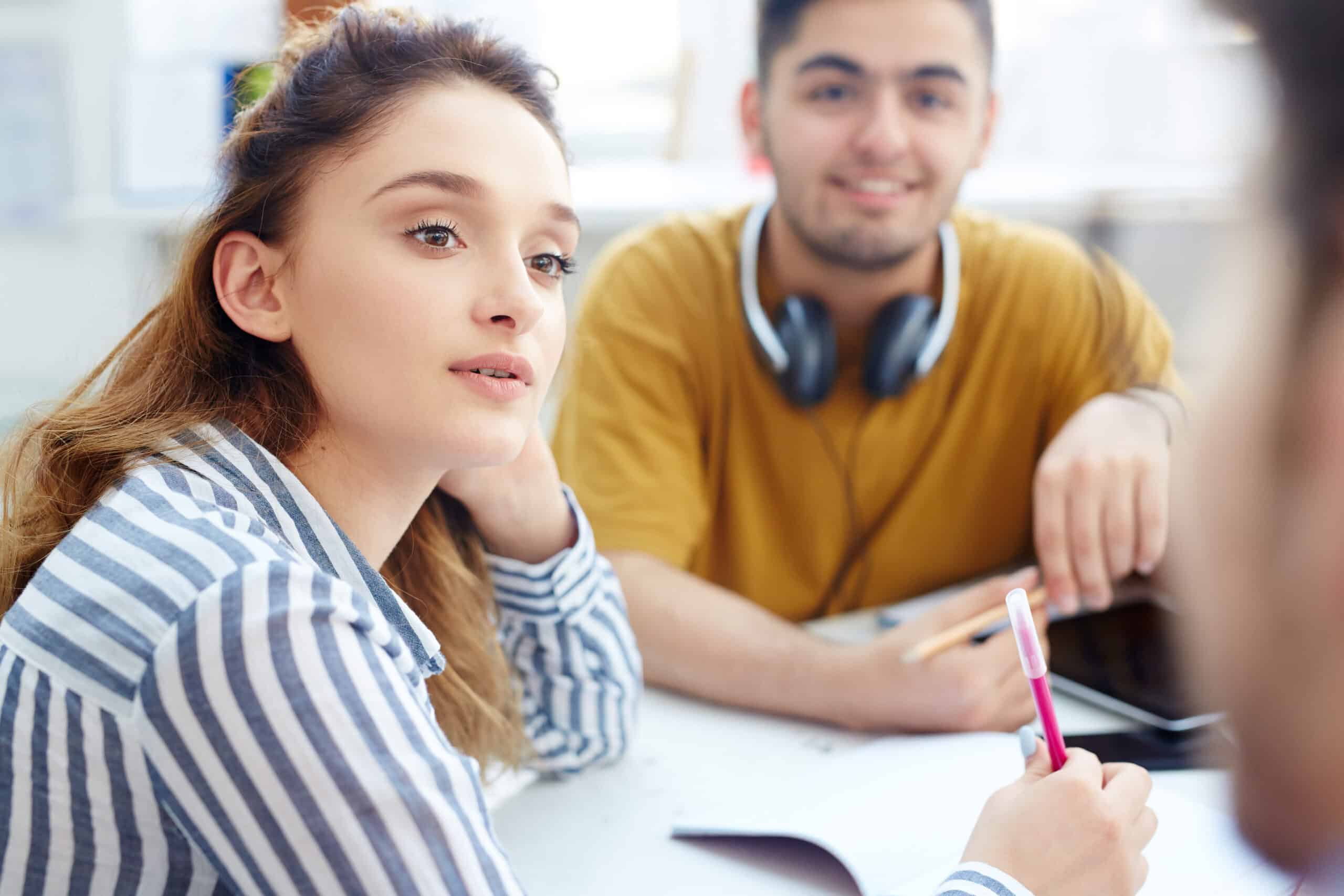 Trois étudiants discutent autour d'une table