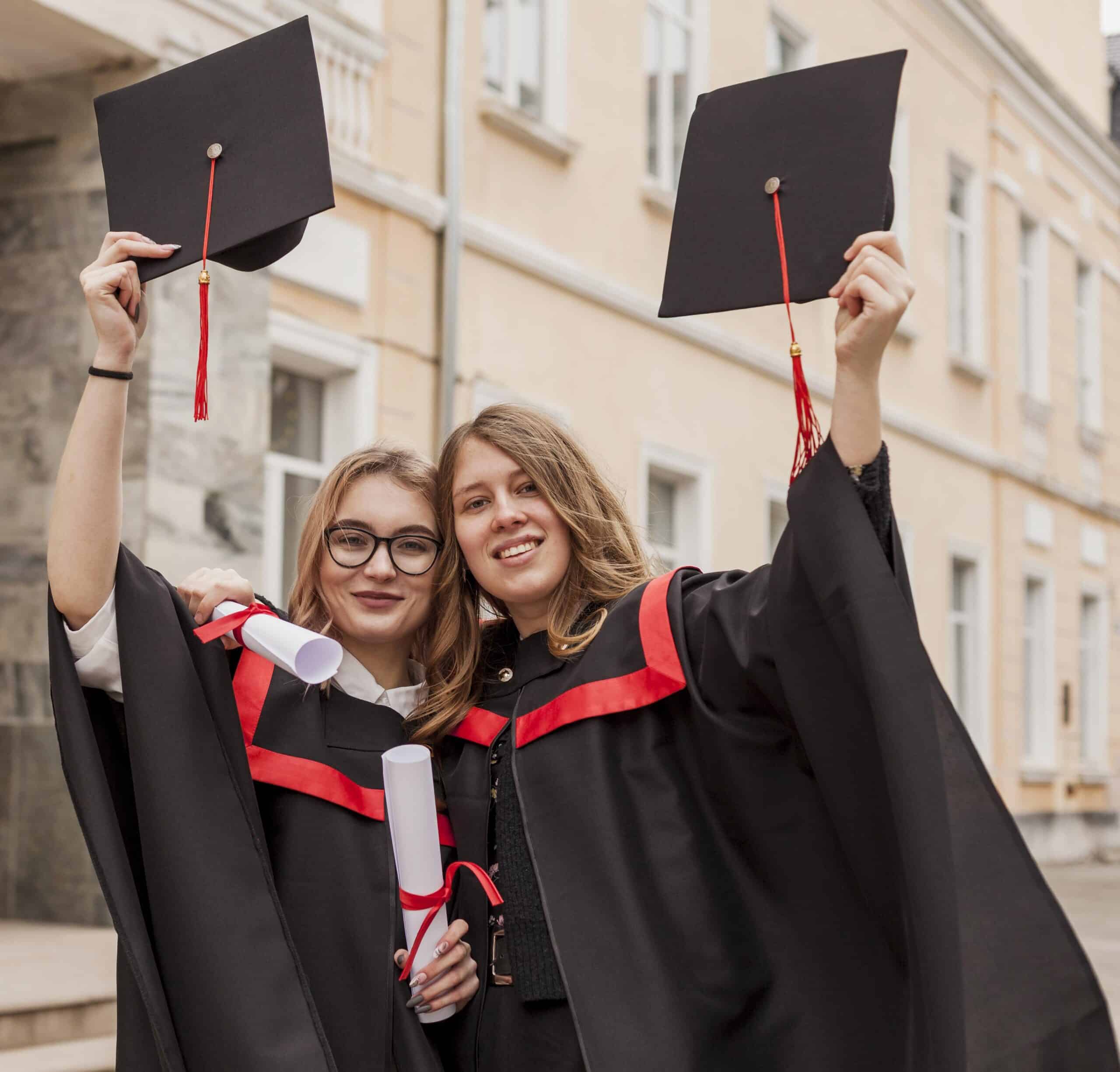 Deux diplômées en toge lèvent leur toque