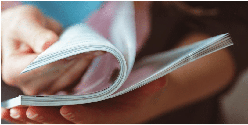 Mains qui feuillettent un magazine