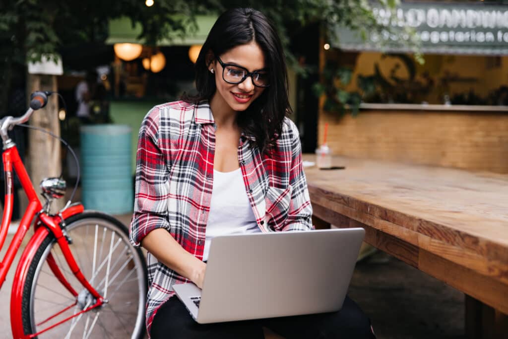 Étudiante travaille sur son ordinateur portable à une terrasse