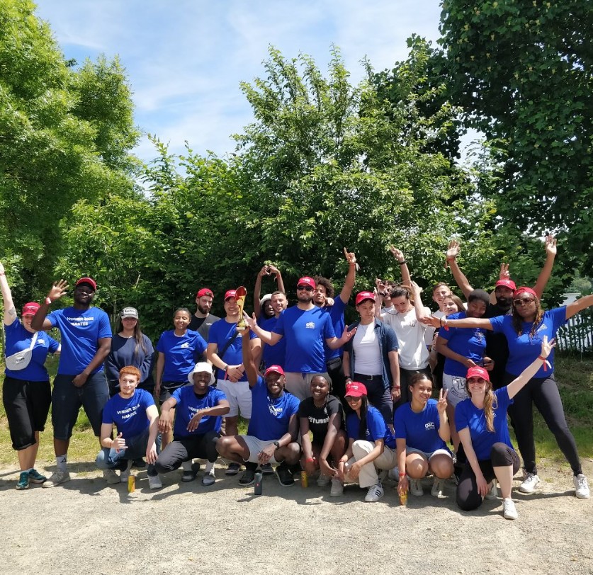 Groupe d'étudiants en tee-shirts bleus posant en extérieur
