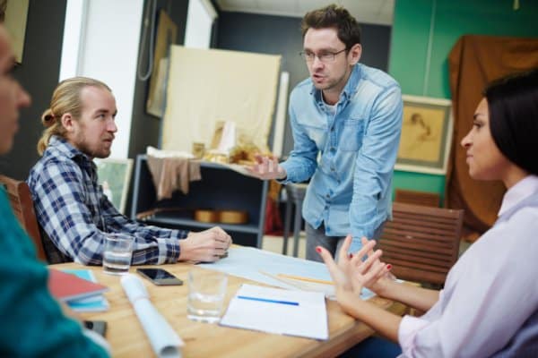 Jeunes professionnels échangeant autour de documents posés sur une table