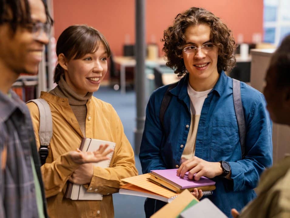 Deux étudiants souriants discutent en classe