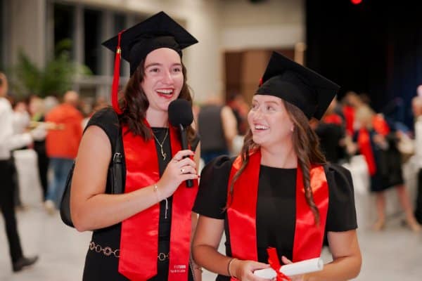 Deux diplômées en toge et toque lors d’une cérémonie de remise des diplômes