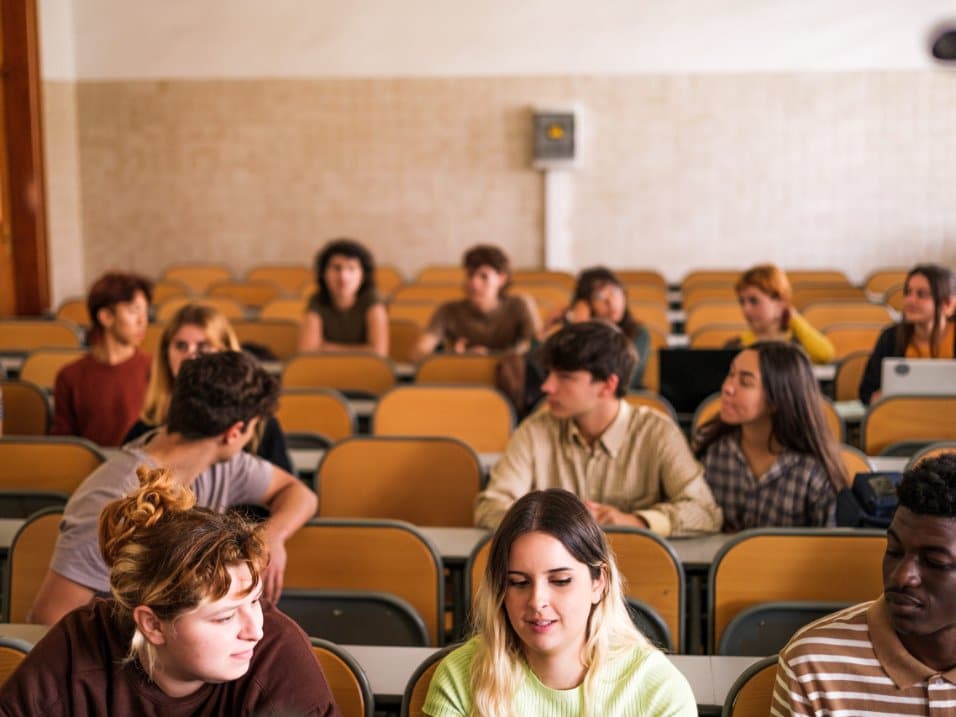 Étudiants de tous âges assis dans un amphithéâtre pendant un cours