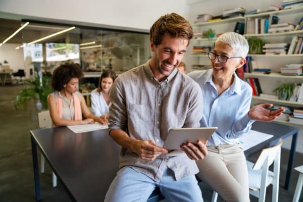 Équipe de bureau échangeant autour d'une tablette