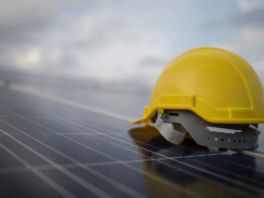 Un casque de chantier posé sur des panneaux solaires