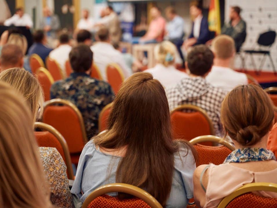 Un public assiste à une conférence dans un amphithéâtre