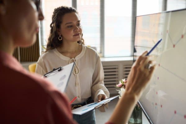 Professionnelle présentant des données sur un tableau blanc