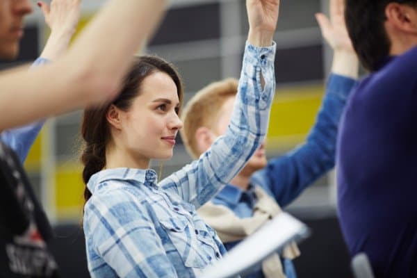 Une apprenante lève la main pendant un cours