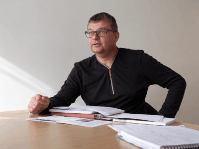 Michel témoigne, assis à une table de réunion