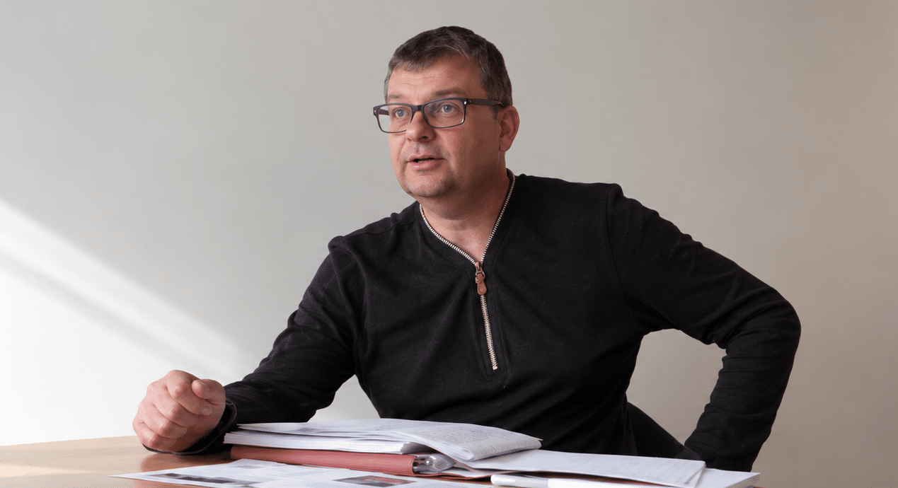 Michel témoigne, assis à une table de réunion
