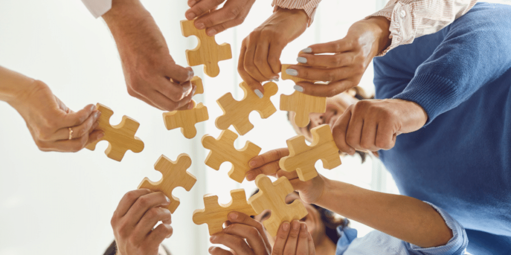 Mains qui assemblent des pièces de puzzle